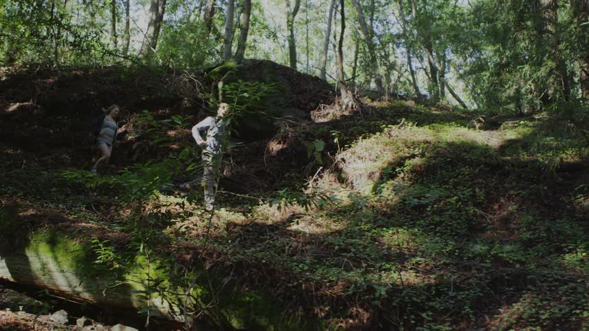 Man and woman jogging downhill through the woods