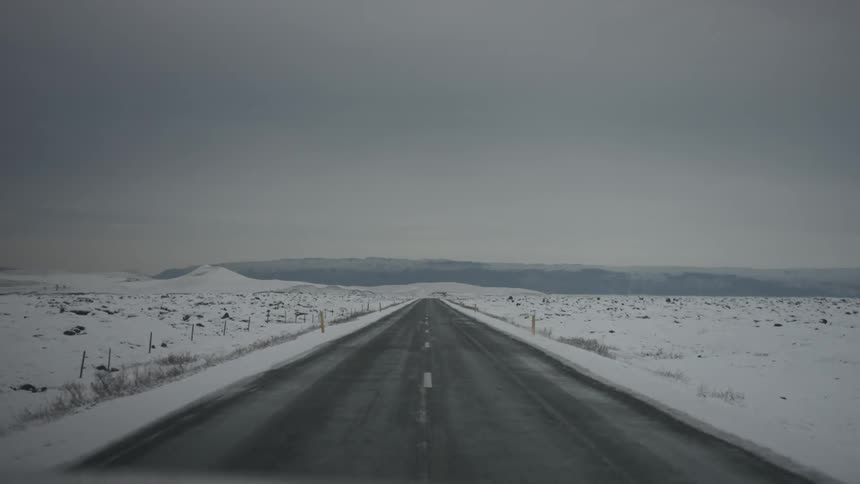 A road is traveled down on a snowy day