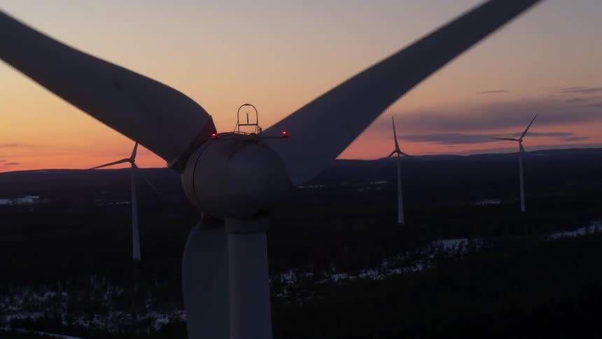 Windmills spinning in rows at sunset