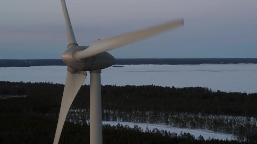 Windmill slowly spinning with field of snow in the background