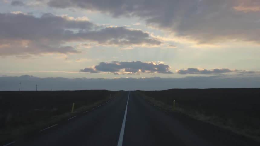 Vehicle drives uphill at dusk