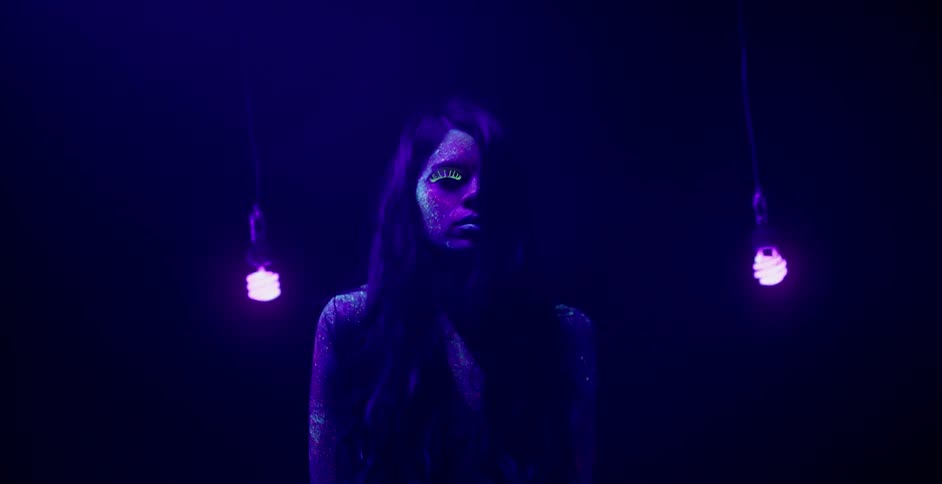Lights swing around a woman in the dark