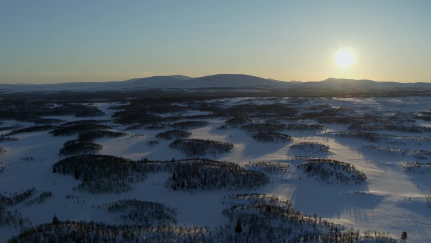The hills are covered with ice and snow at sunset