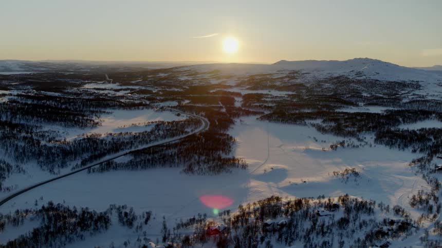 The sun is setting over the snow covered horizon