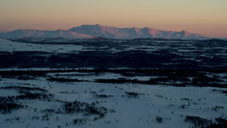 The fields are long full of ice leading to the mountain at dawn