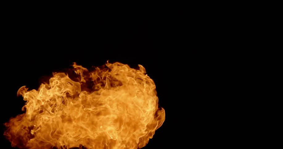 A man blows fire at night