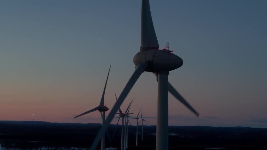 Wind turbines rotate at sunset
