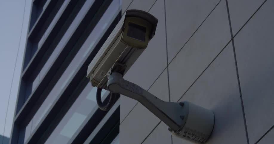 A surveillance camera is on the side of the building