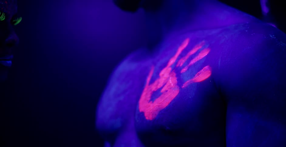 A woman leaves a colorful handprint on a man's chest
