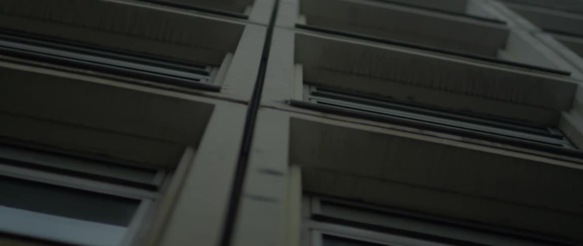 An office building is being filmed straight up from the sidewalk