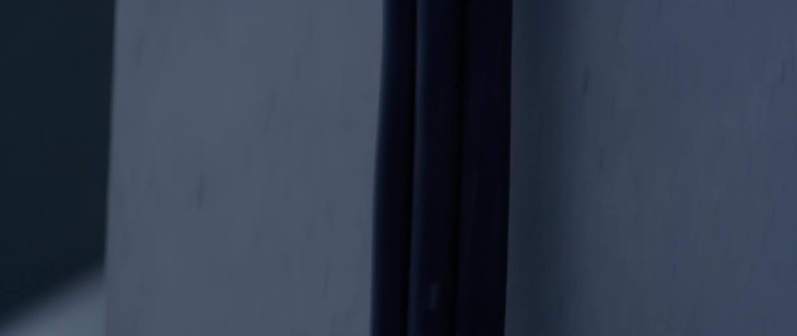 A cord runs up a concrete wall