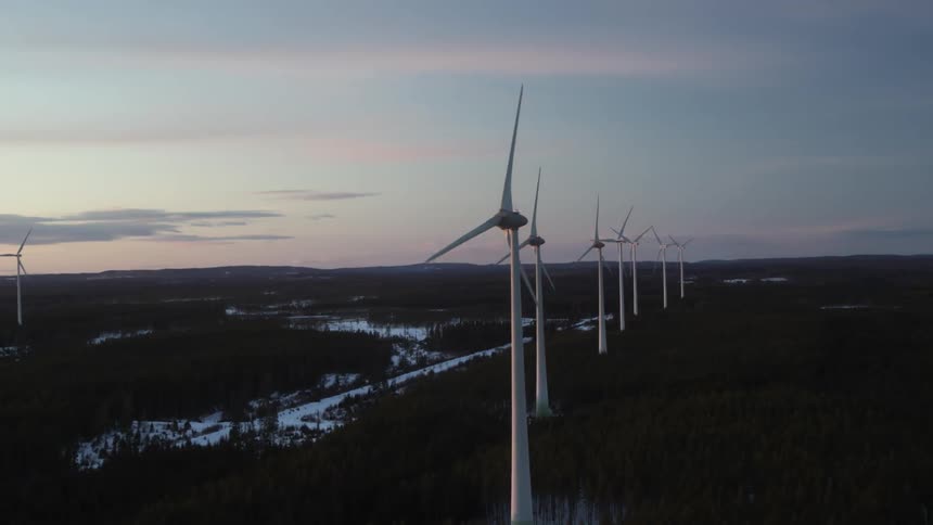 Wind turbines rotate at sunset