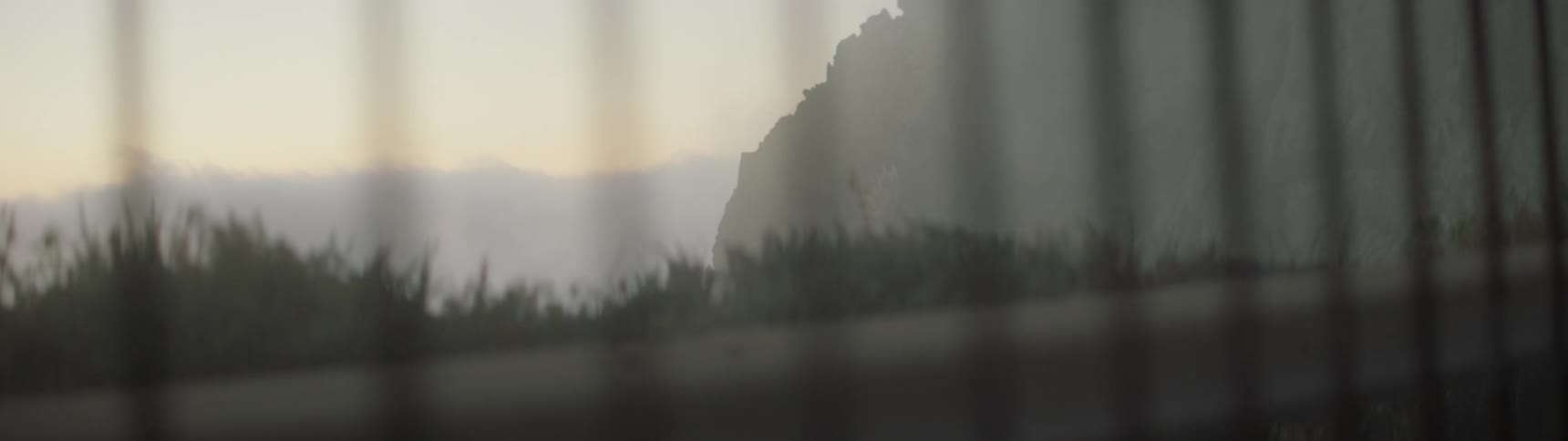 Past the fence is a cliff with fog