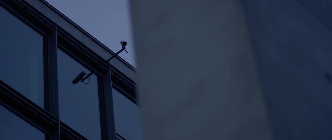 Security cameras are attached to the top of a building
