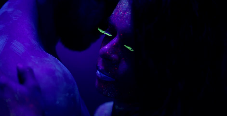 A man and woman in glowing paint dance