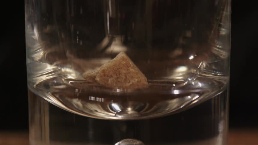 An ingredient is added to an empty glass