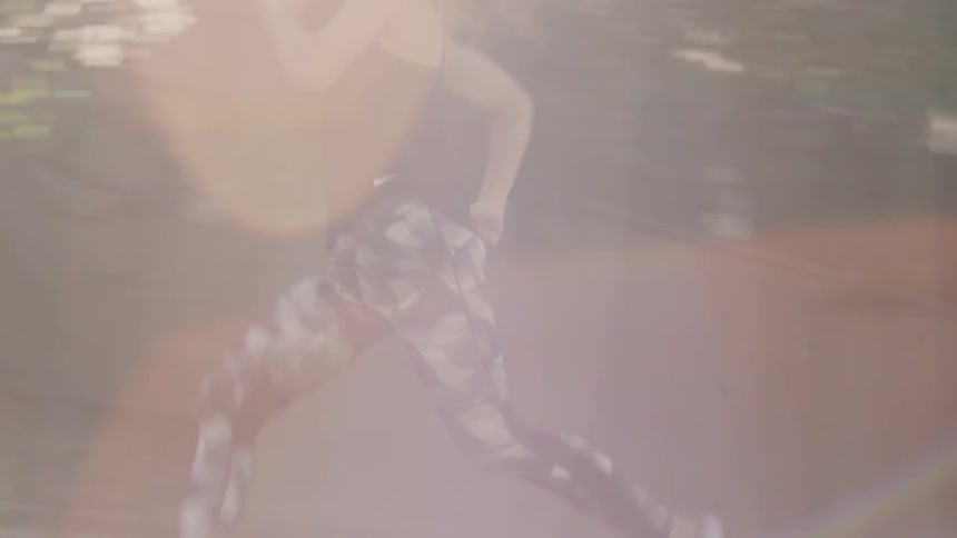 A woman is sprinting across the grass