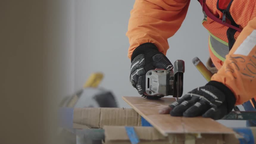 A man is using a saw on a piece of wood