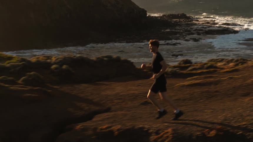 A man runs up the hills near the shore