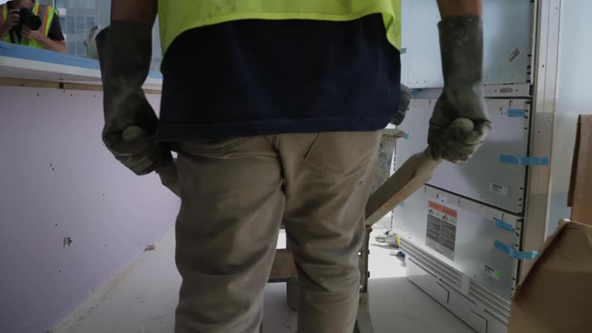 A man is using a wheelbarrow on a construction site