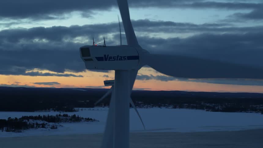 Wind turbines in a wind farm are spinning at dawn