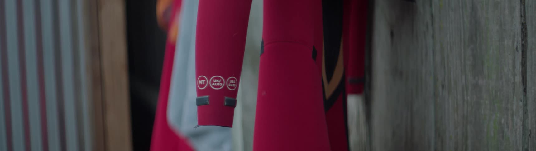 A wetsuit hangs next to a wall