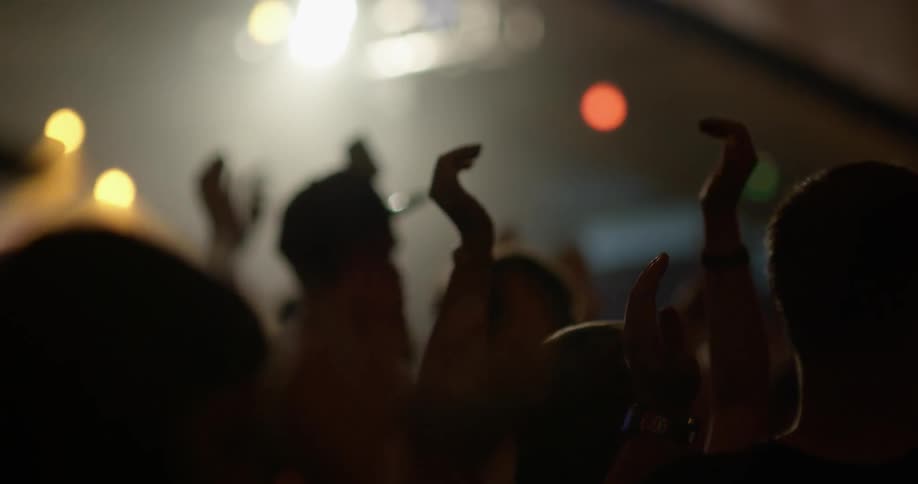 People dance and clap in a dance club