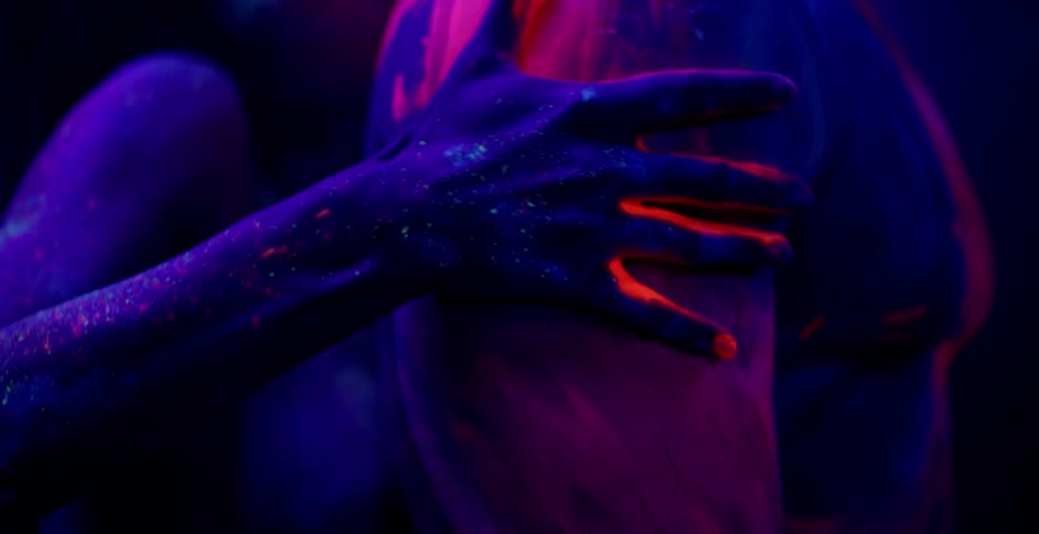 A woman rubs a man's shoulders with paint