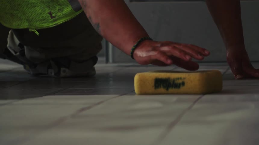 A man is wiping the ground with a sponge