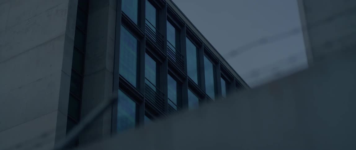 Barbed wire is being filmed along with glass windows of a building
