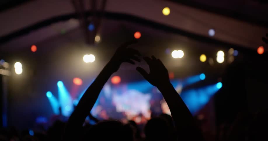 People dance and clap in a dance club
