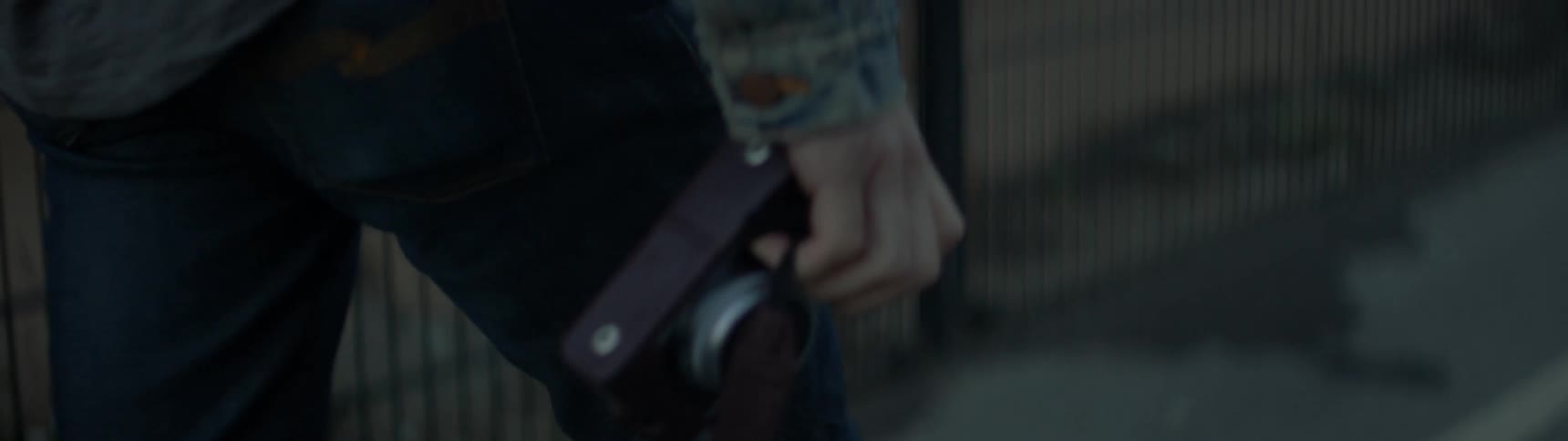 Someone is walking down the street holding a camera