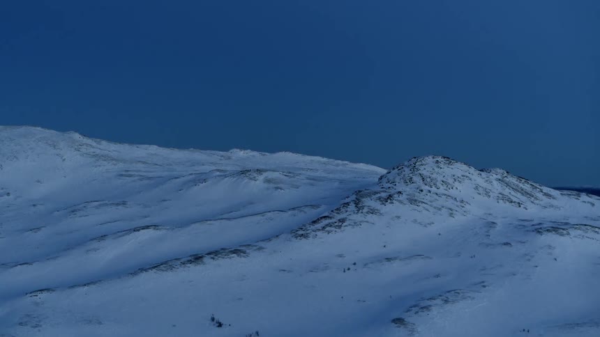 Snow covers the front of a mountain