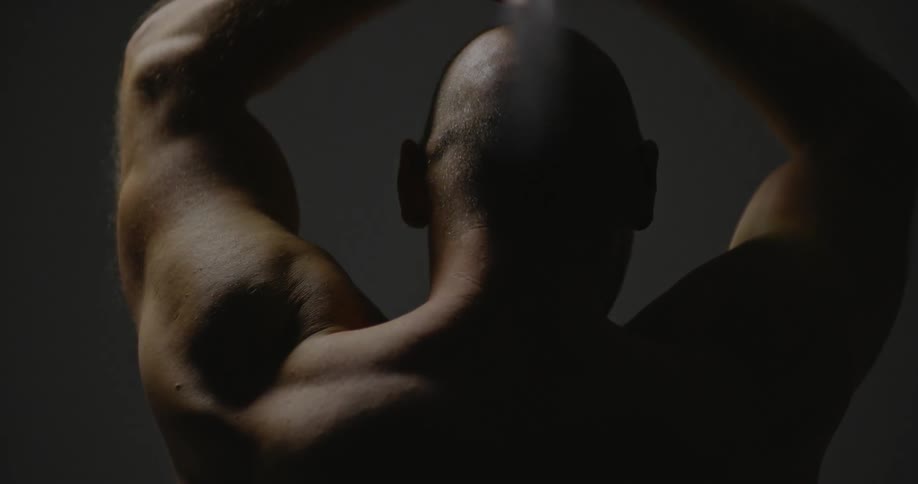 A bald man raises a sword above his head