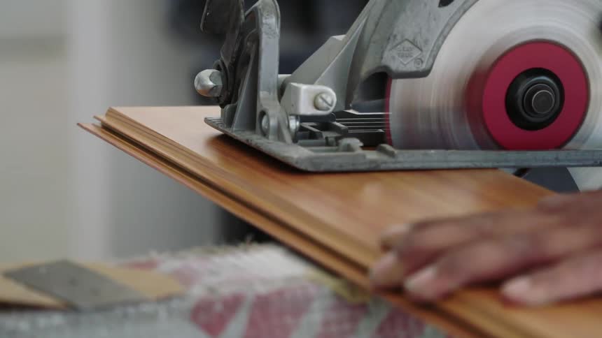 A man cuts a board with a power saw