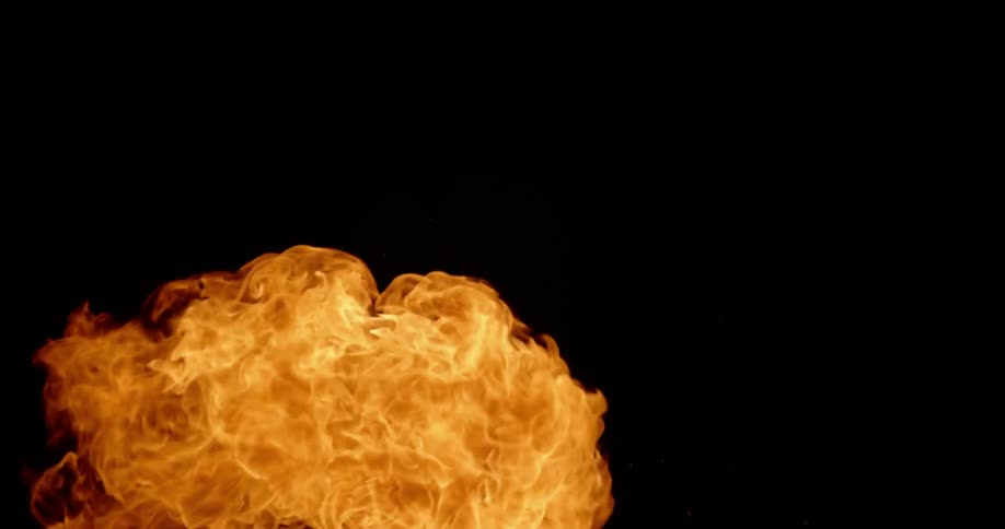 Man blowing on and igniting fire torch at night