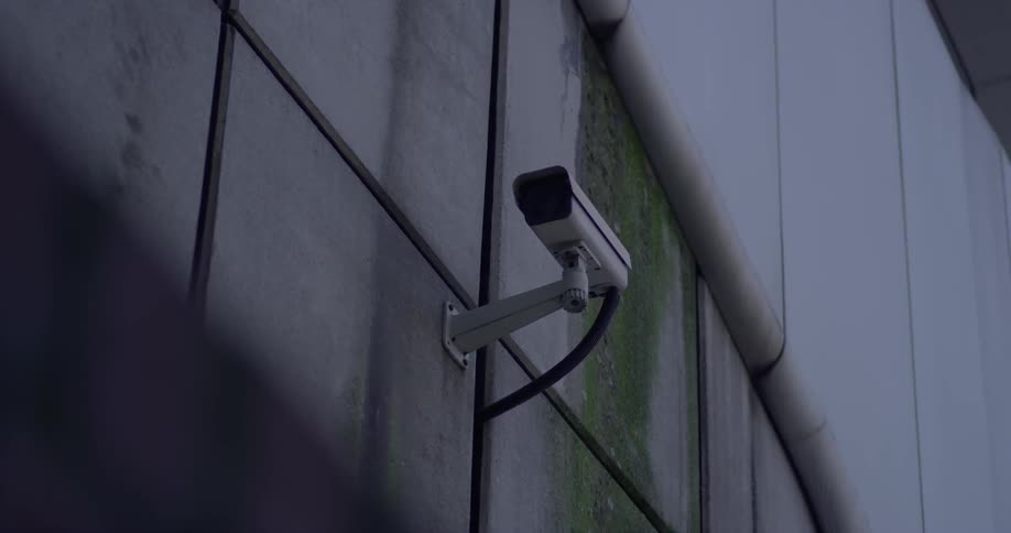 A camera sits mounted on the side of a building