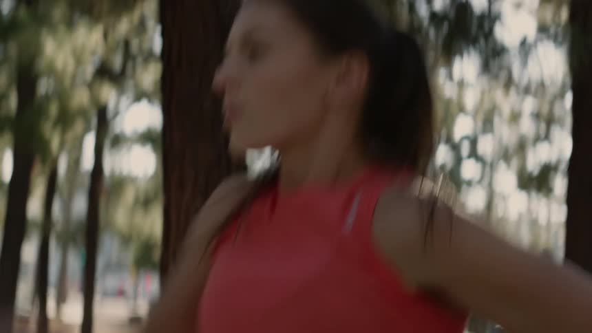A woman exercises in a sunny park