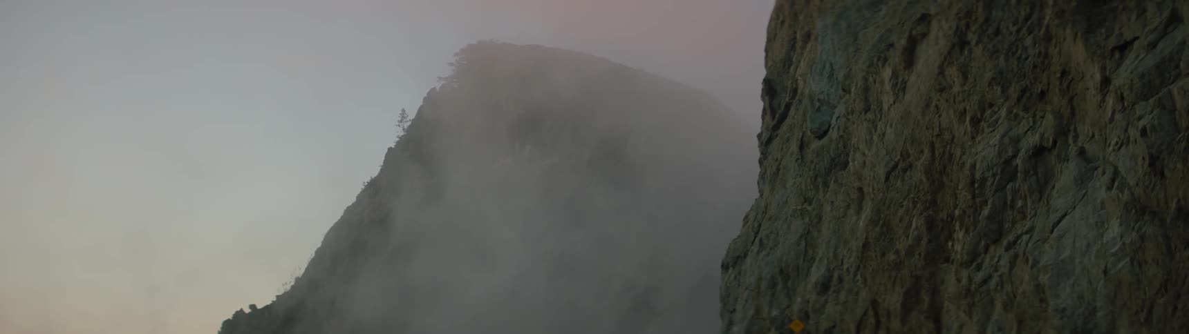 Fog drifts in the space between two cliffs