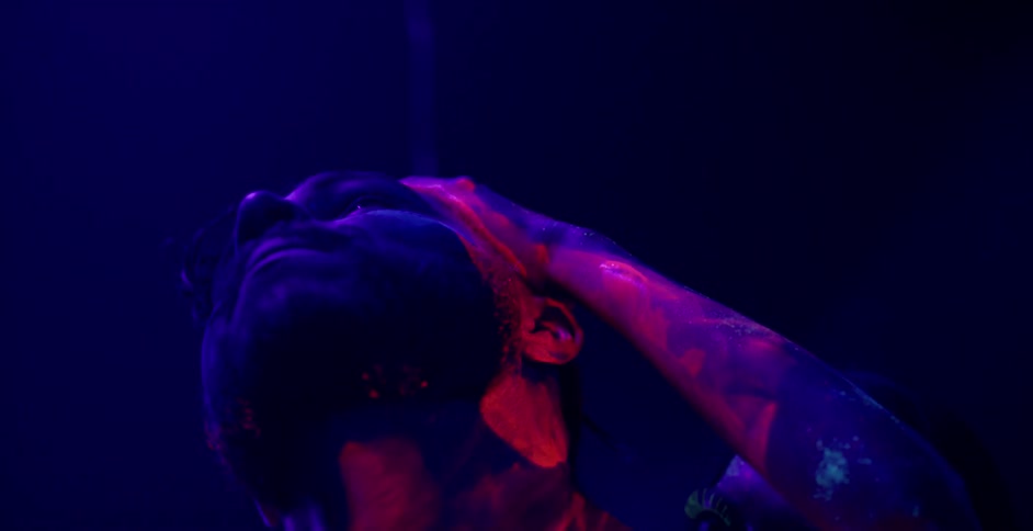 A woman sensually rubs paint into a man's neck and head