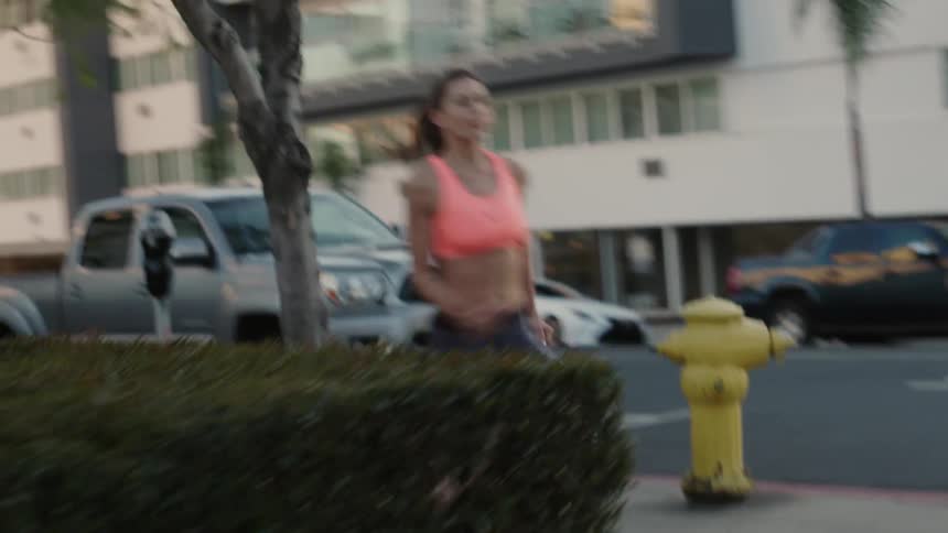 A woman is jogging on a city street