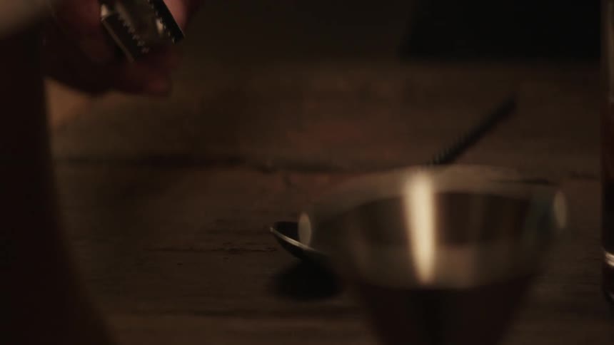 A bartender is picking up tongs