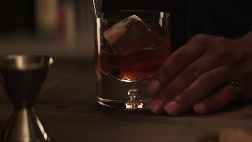 A bartender is stirring a drink