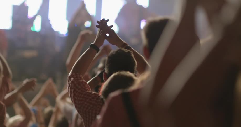 A large group of people are enjoying a concert in slow motion