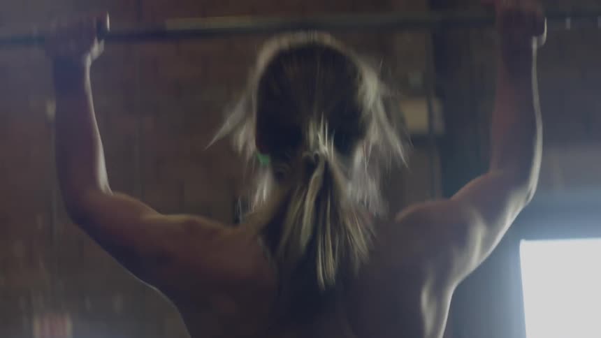A woman lifts weights in a gym