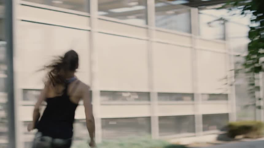 A woman jogs in a city on a sunny day