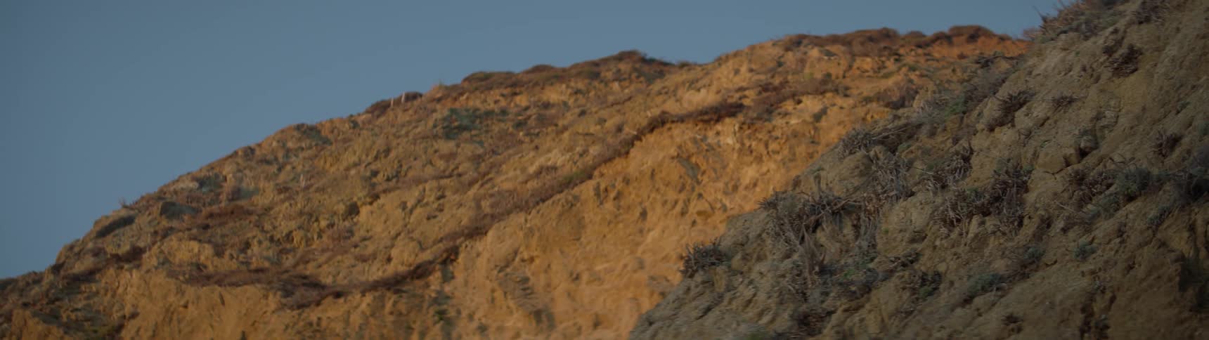 The hill is covered with rocks and grass