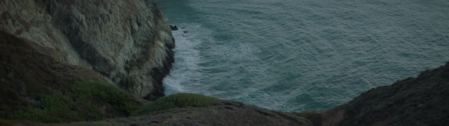 The water crashes against the side of the cliffs
