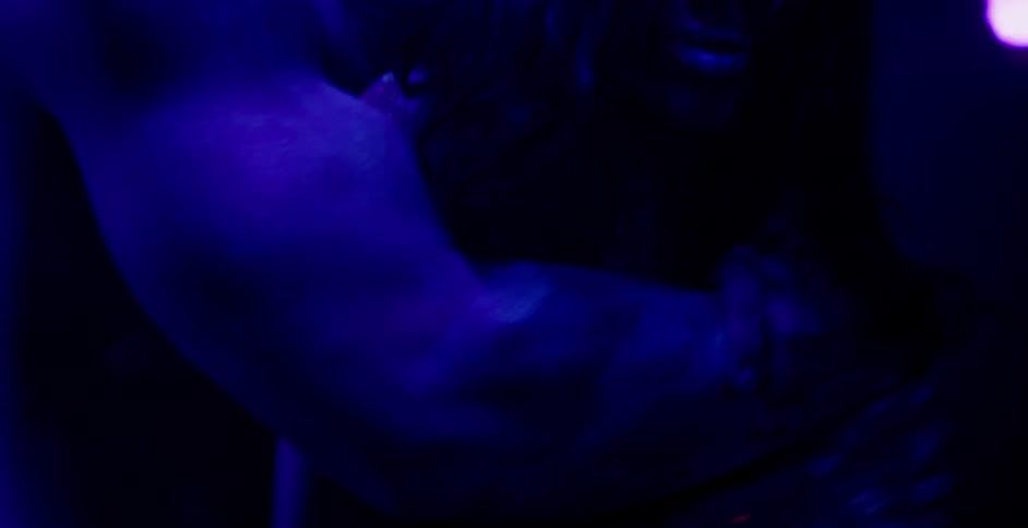 A man and woman embrace while covered in glowing body paint