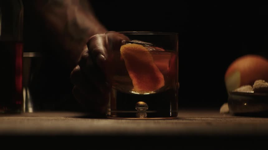 A bartender pushes a drink forward